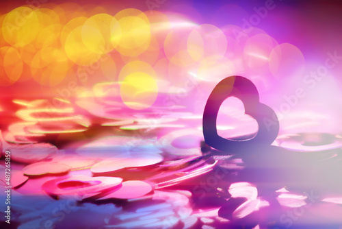 Abstract colored background. Red toy in the shape of a heart on a glitter and bokeh background.