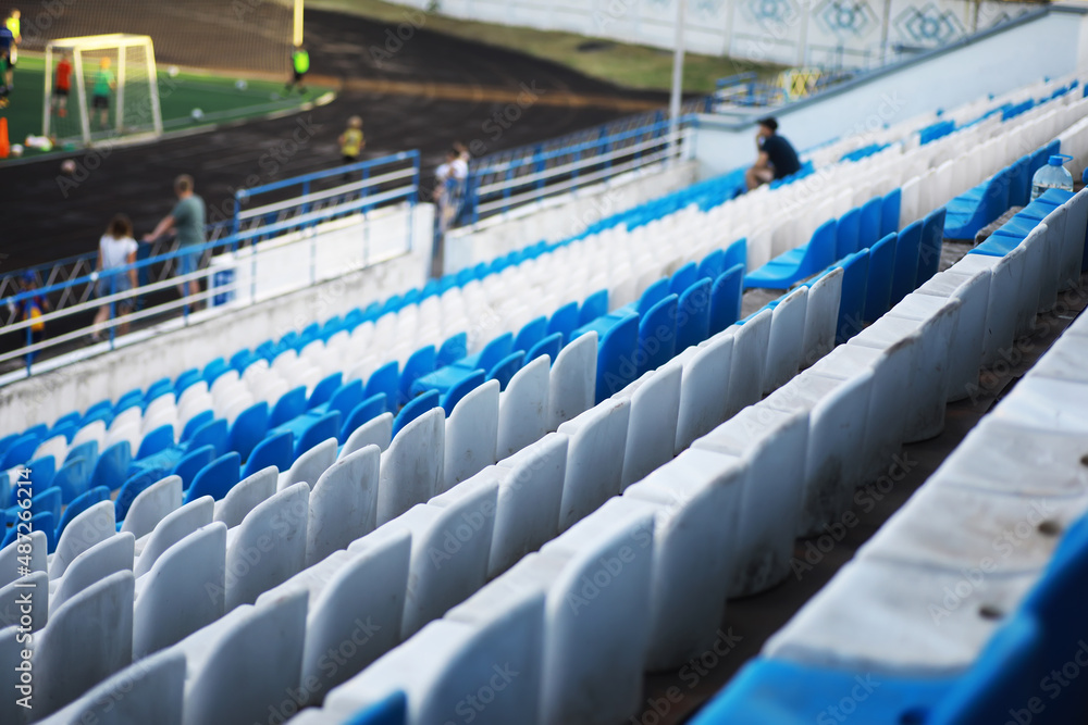 Fototapeta premium Plastic chairs in the stands of a sports stadium. Cheer on the stands of the stadium.