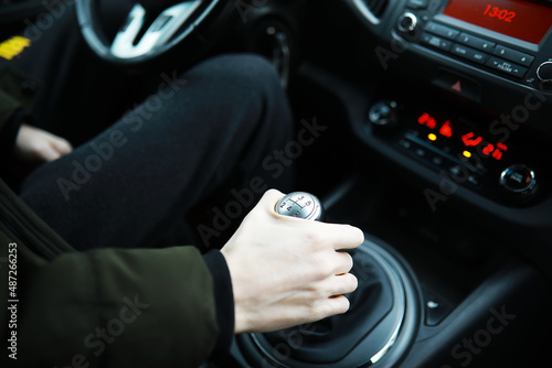 Hand on the car gear knob. The driver switches the speed in the car. Hand on gear lever.