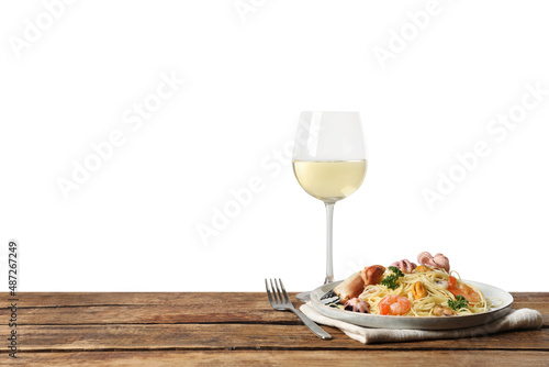 Delicious spaghetti with seafood served on wooden table against white background