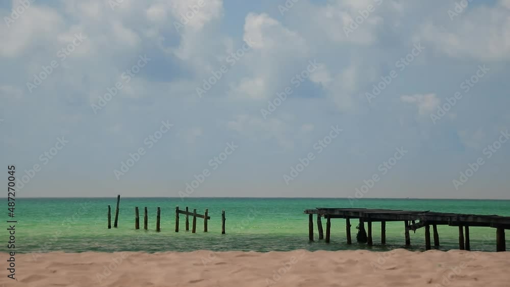 Long shot of a broken wooden boardwalk on the vast horizon of the between the blue sea and sky at Soksan Beach in Koh Rong Island Cambodia Long shot of a broken wooden boardwalk on the vast horizon of the between the blue sea and sky at Soksan Beach in Koh Rong Island Cambodia