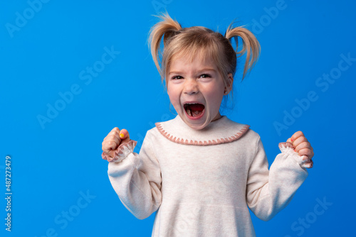 Foto Naughty little girl over the blue background