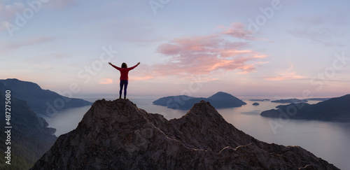 Adventurous Adult Woman Hiker on top of Rocky Mountain with hands open. 3D Rendering Peak. Sunset Sky. Background from British Columbia, Canada. Adventure Sport Concept