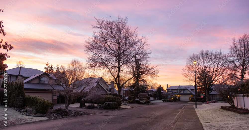 View of Residential Suburban Neighborhood Street in a modern city. Frosty Cloudy Winter Morning Sunrise Sky. Fraser Heights, Surrey, Vancouver, British Columbia, Canada.