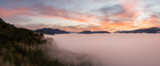 Aerial Panoramic View of Canadian Mountain Landscape covered in fog over Harrison Lake. Dramatic Colorful Winter Sunset Sky Art Render. British Columbia, Canada. Nature Background Panorama