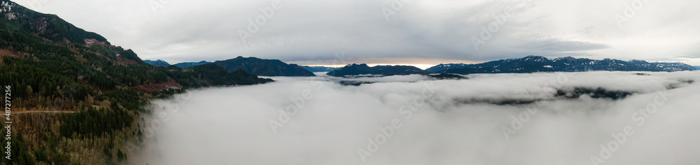 Aerial Panoramic View of Canadian Mountain Landscape covered in fog over Harrison Lake. Winter Season. British Columbia, Canada. Nature Background Panorama