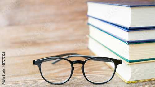 Glasses on the background of a stack of books. Image with selective focus