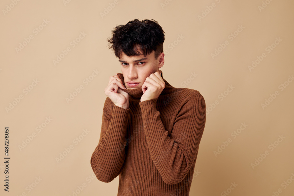 portrait of a young man posing in brown sweater self confidence fashion isolated background unaltered portrait of a young man posing in brown sweater self confidence fashion isolated background unaltered