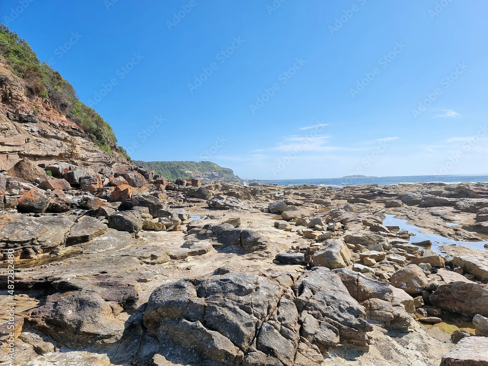 Rock Platform with rock pools at Hams Beach Newcastle Australia. With a blue sky and a few clouds