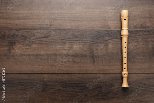 Fototapeta Wooden recorder on the wooden background