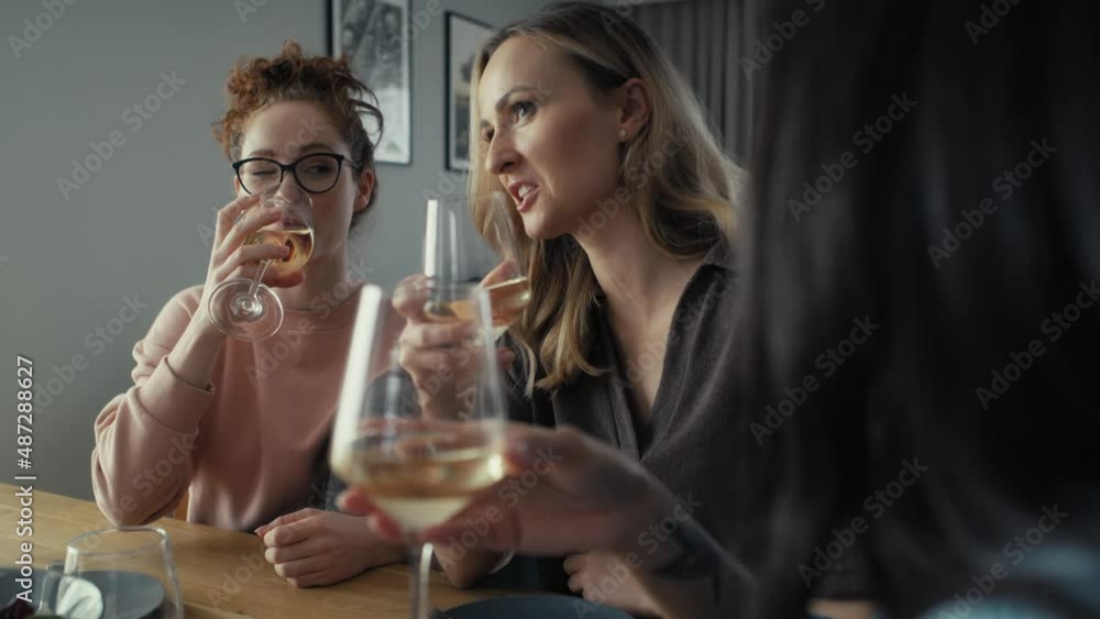Three female caucasian friends chatting and drinking wine at home. Shot with RED helium camera in 8K Three female caucasian friends chatting and drinking wine at home. Shot with RED helium camera in 8K