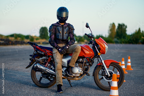 Male student poses on motorbike  motorcycle school