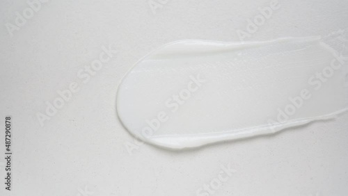 Small metal shovel swipes moisturizing cream over white background upper macro view. Professional cosmetic product for wellness