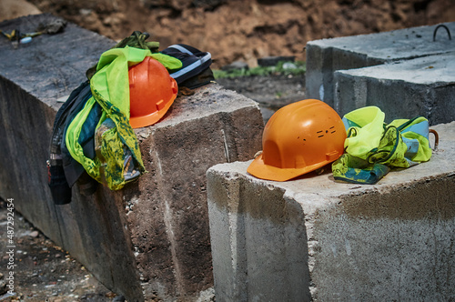Wallpaper Mural Yellow safety vests and high-visibility helmets lie on concrete slabs. The workers left. Construction site in summer. Dinner. No people. Selective focus in the foreground. Torontodigital.ca
