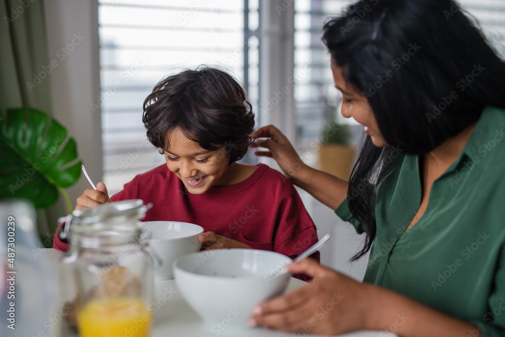Happy little boy having breakfast with his mother at home. Happy little boy having breakfast with his mother at home.