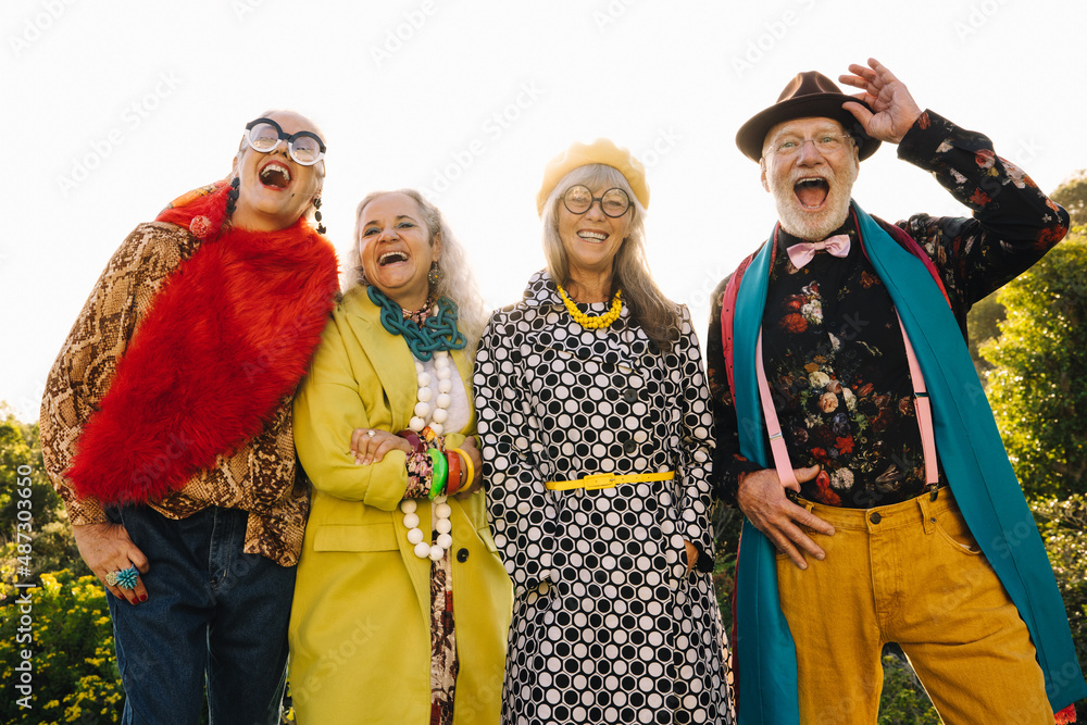 Group of eccentric mature friends laughing happily in a park