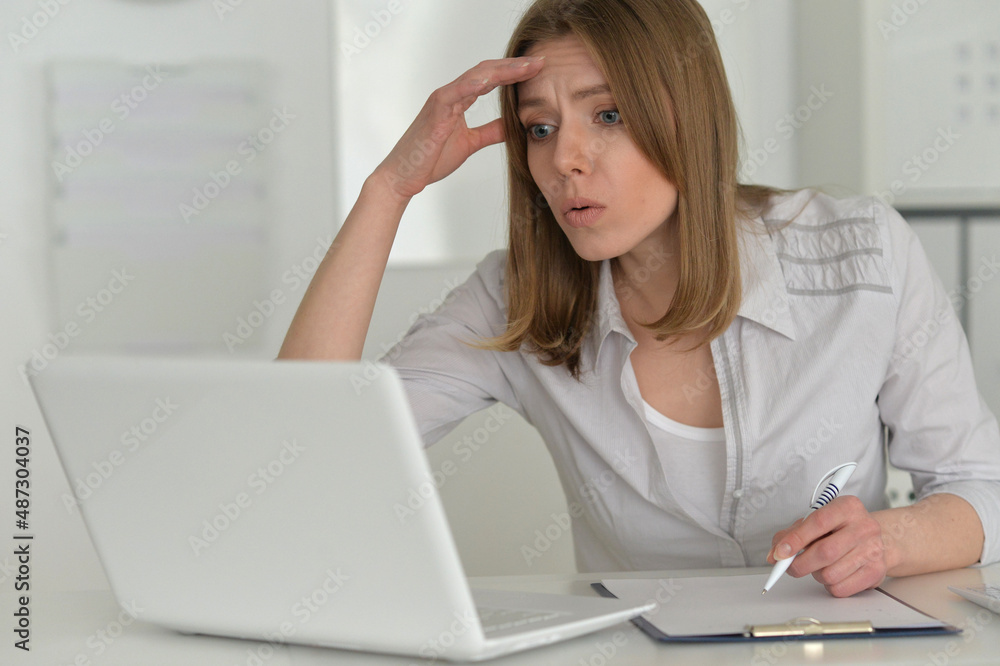 young sad business woman working in office with laptop young sad business woman working in office with laptop