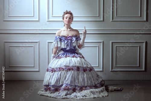 Vintage portrait of young adorable girl in image of medieval royal person in renaissance style dress isolated on retro background. Comparison of eras, history, movie