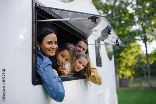 Cuadro en lienzo Happy young family with two children looking out of caravan window