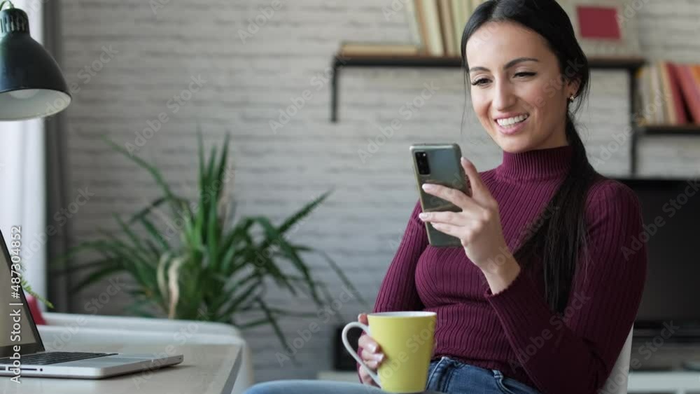 Video of beauty business woman sending messages with her mobile phone while working and drinking coffe at home. Video of beauty business woman sending messages with her mobile phone while working and drinking coffe at home.