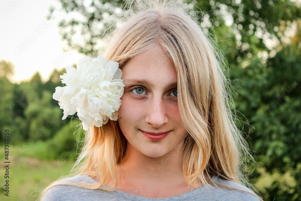 young blonde girl with a white flower in her hair, smile young blonde girl with a white flower in her hair, smile