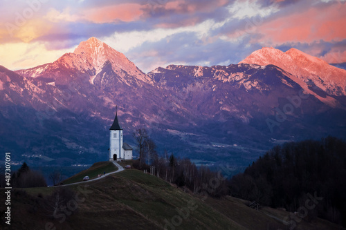 church in fresh frosty evening sun in winter mountains of the slovenian alps at sunset