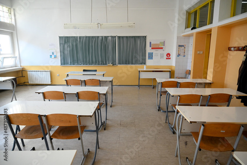 Classroom with blackboard for studying lessons. Empty classroom in elementary school. Rows of chairs and tables in classroom in high school. Lecture room. Education.