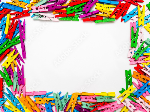 frame from multi colored wooden decorative clothespins, horizontal photo with place for text on white background and copy space