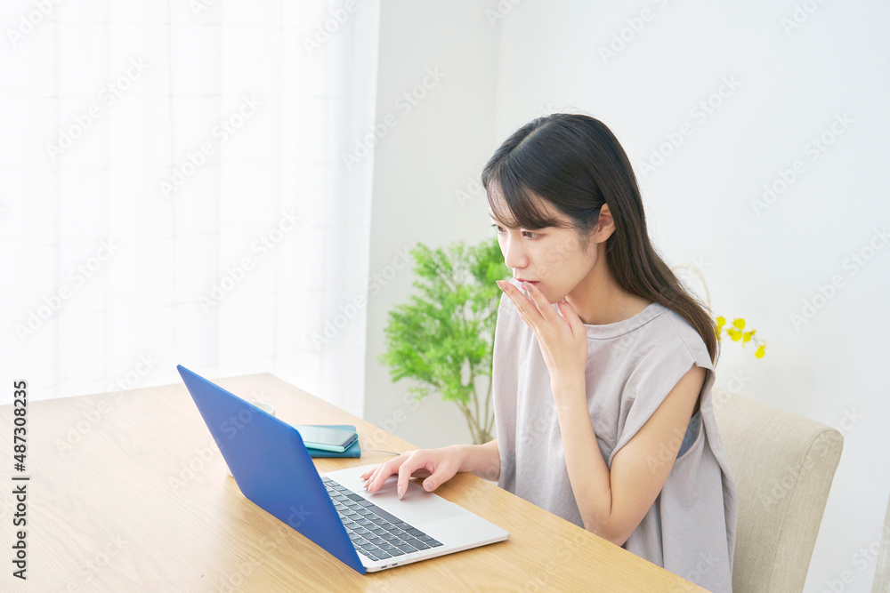 女性 パソコンを見て驚く リビング 女性 パソコンを見て驚く リビング