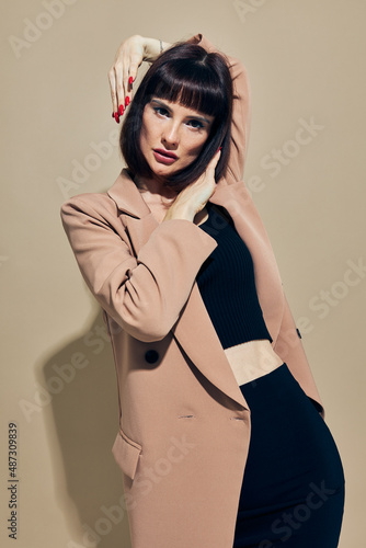 beautiful woman short haired suit gesturing with hands light background