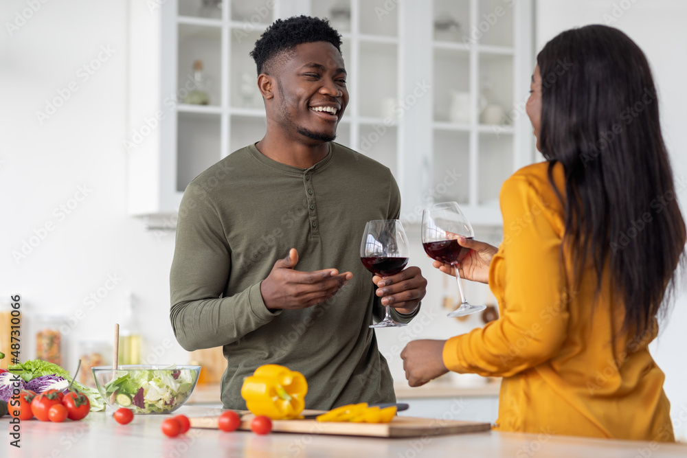 Aperitif Drink. Cheerful Black Man And Woman Drinking Red Wine In Kitchen Aperitif Drink. Cheerful Black Man And Woman Drinking Red Wine In Kitchen
