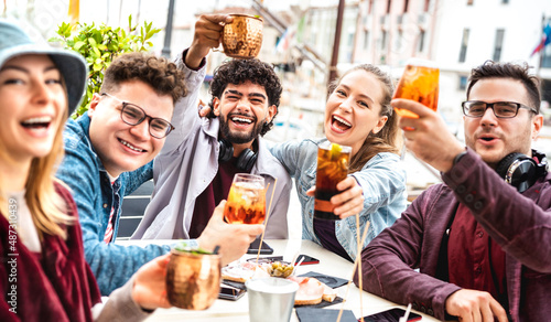 Multicultural friends taking selfie at fancy pub restaurant out side - Life style concept with young people having fun together on happy hour at sidewalk cafe - Vivid filter with focus on central guy