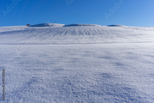 hill full of white snow with blue sky