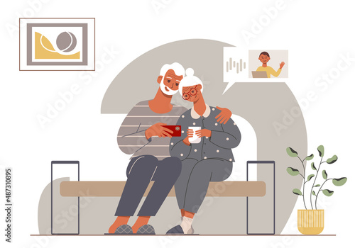 Modern elderly couple talking with their grandson online. Stylish grandpa and grandma sitting on a sofa in a cozy home.