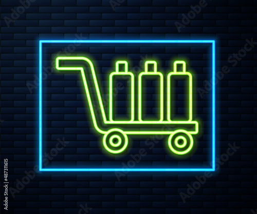 Glowing neon line Trolley suitcase icon isolated on brick wall background. Traveling baggage sign. Travel luggage icon. Vector