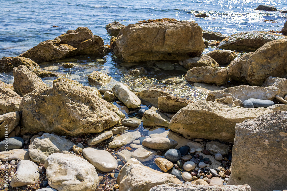 Sea rocks, stones and pebbles on the beach in sunlight Sea rocks, stones and pebbles on the beach in sunlight