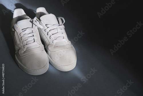 A pair of sports light sneakers stands on a fitness mat in the shade and in the rays of the sun