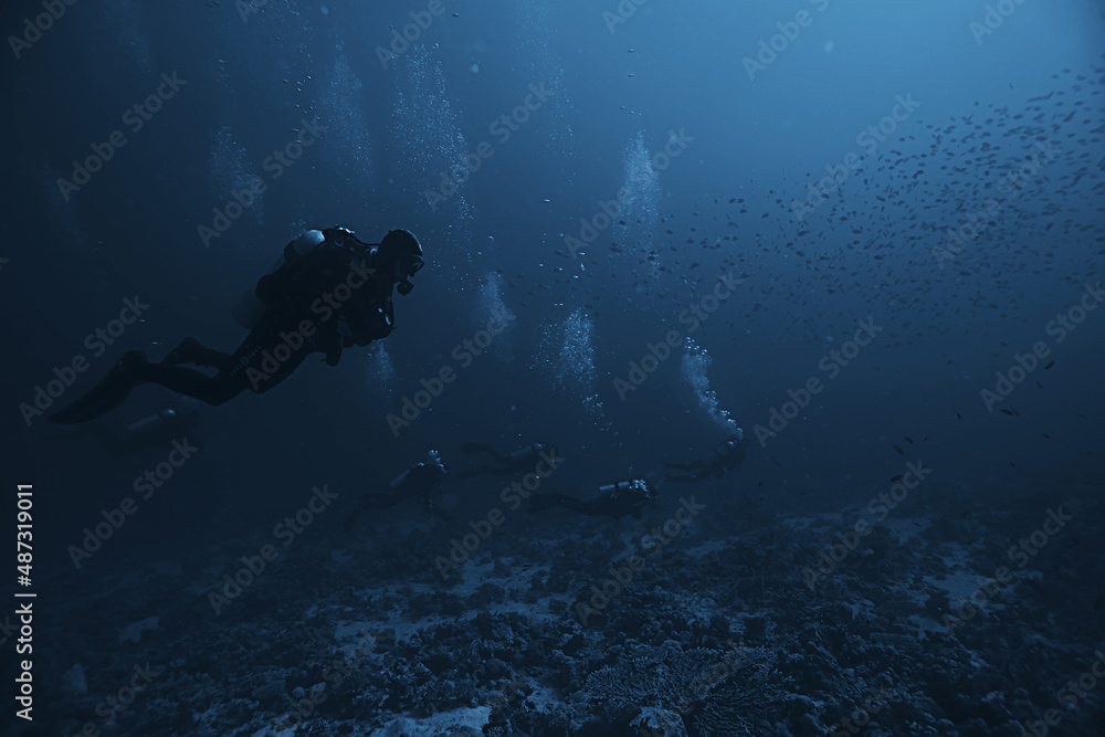 divers underwater at depth in the blue sea background divers underwater at depth in the blue sea background