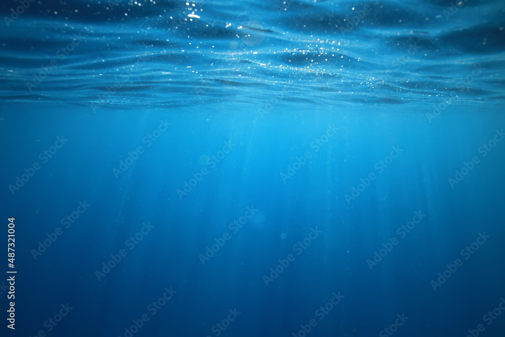 Obraz premium ocean underwater rays of light background, under blue water sunlight