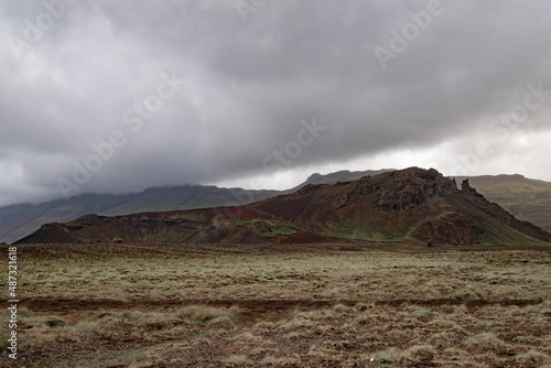Tief hängende Regenwolken über einem Vulkankegel im Hítardalur auf der Halbinsel Snæfellsnes