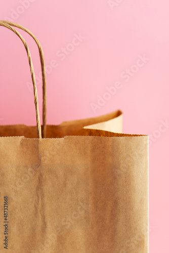 Kraft package on a pink background close-up. Eco packaging, saving the planet. Zero waste.