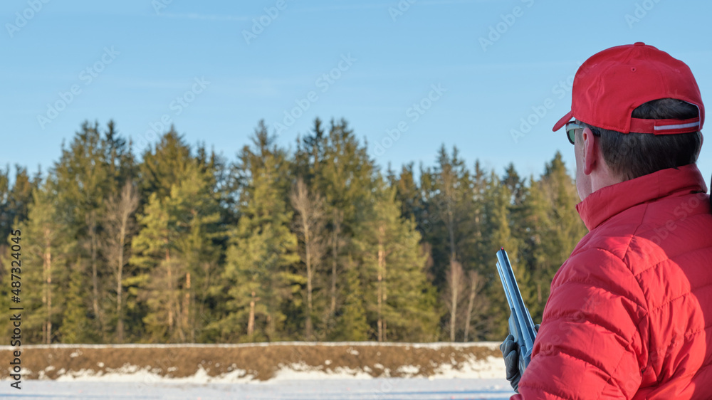 sportsman left-handed shooter prepared for the departure of a clay pigeon on the left, shooting at the stand sportsman left-handed shooter prepared for the departure of a clay pigeon on the left, shooting at the stand