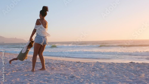 Woman spinning in a circle her daughter at beach