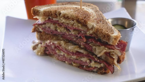 A classic stacked deli reuben sandwich on marble rye bread, slider close up 4K photo