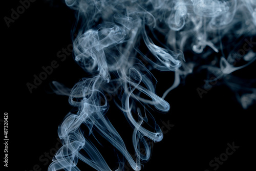 Twisted plumes of smoke, smoke movement on a black background. Abstract smoke lines