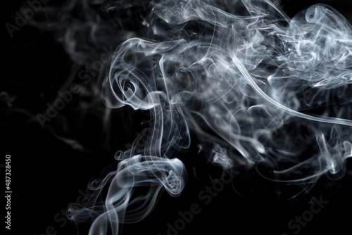 Twisted plumes of smoke, smoke movement on a black background. Abstract smoke lines