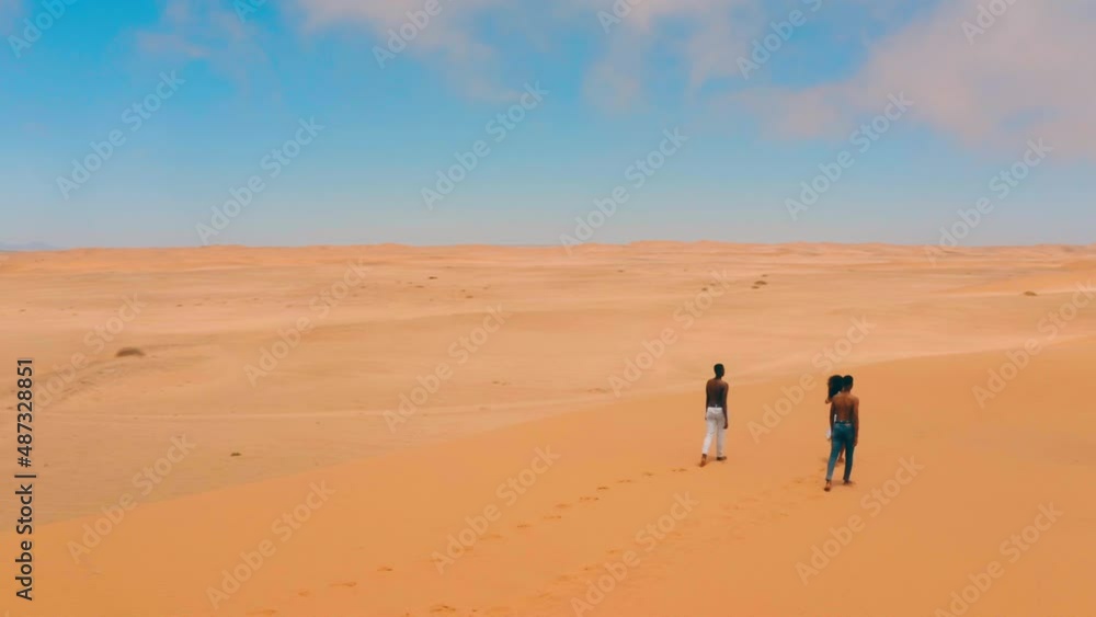 Drone Shot of three people walking in desert in Namibia Drone Shot of three people walking in desert in Namibia