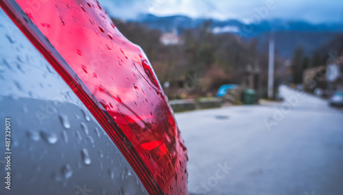 Photography Rear light of a subcompact car in the rain, in winter, italy