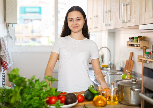 Portrait of beautiful woman posing with healthy green food at home kitchen