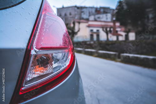 Fotografie Rear light of a subcompact car in the rain, in winter, italy